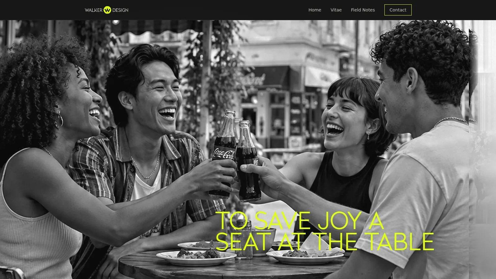 Four friends laughing and raising bottles of Coca-Cola at a café table, in black and white.