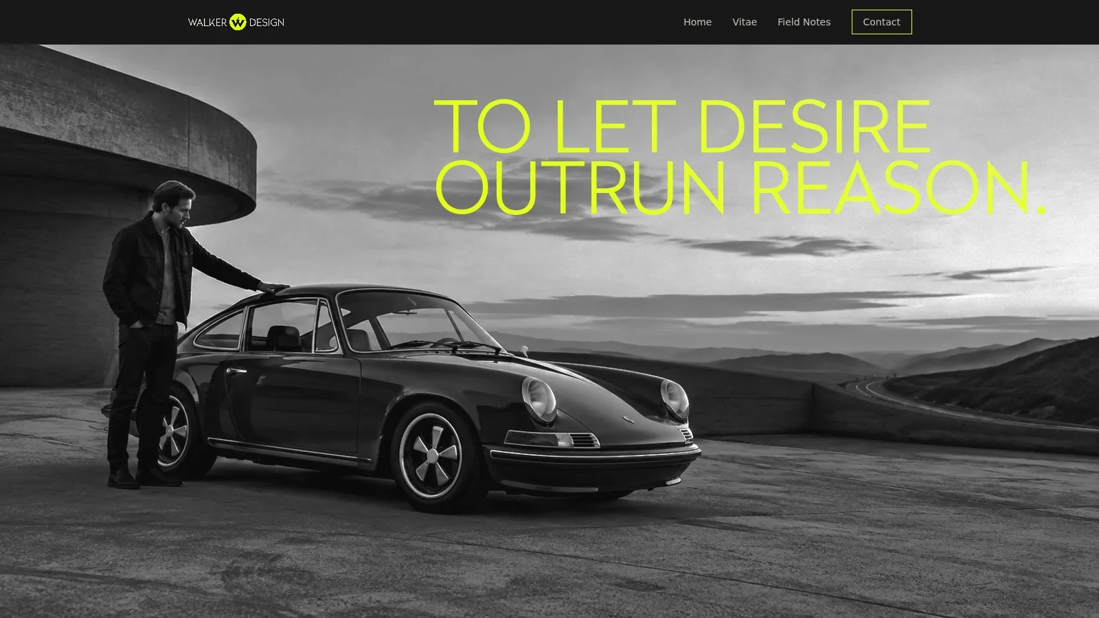 A man beside a classic Porsche 911 at a coastal overlook, in black and white.