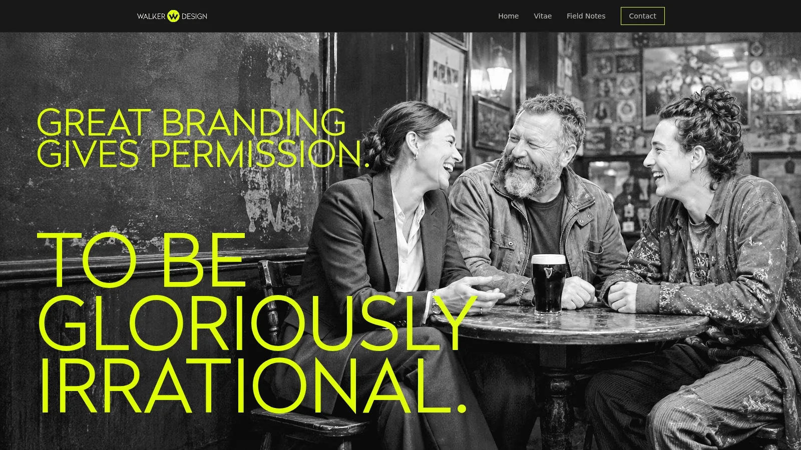 Three friends laughing over pints at a pub table, in black and white.