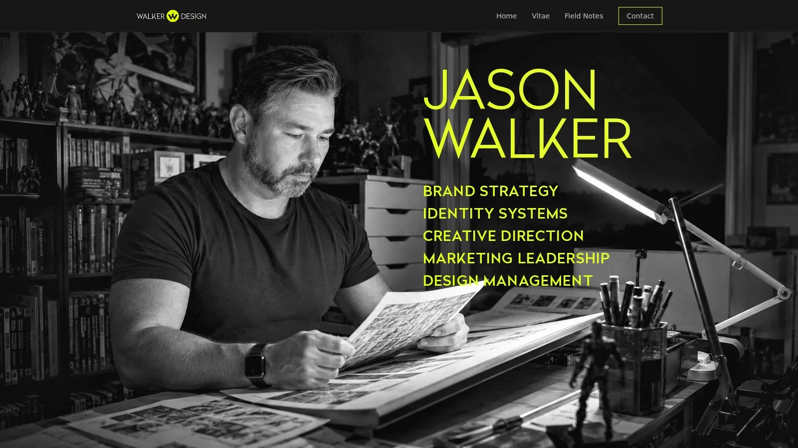 Jason Walker reading at his desk, in black and white.